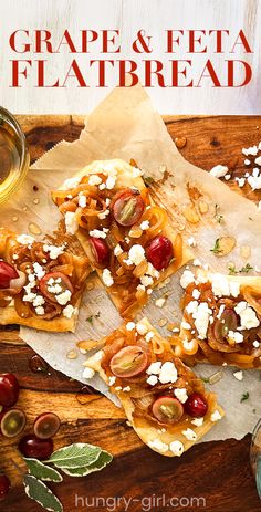 grapes and feta flatbreads on parchment paper next to a glass of wine