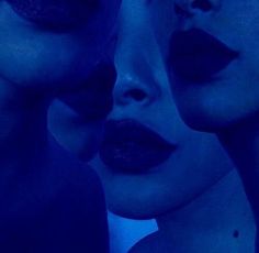 two women with blue makeup are looking at each other