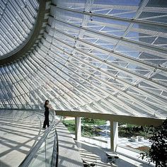 the inside of a building with people walking and sitting on benches in front of it