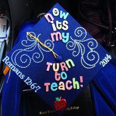 a blue graduation cap with the words now it's my turn to teach