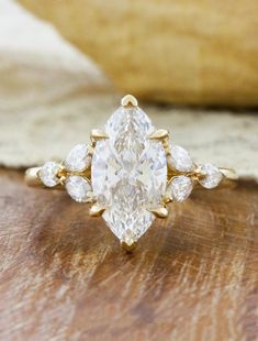 a pear shaped diamond ring on top of a wooden table