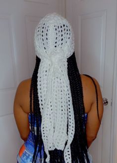 the back of a woman's head wearing a white crochet hat and scarf