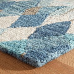 a blue and white rug on top of a wooden floor