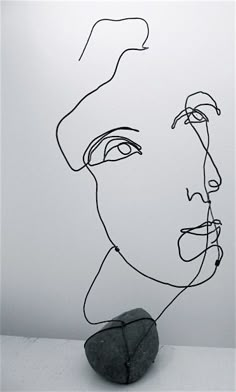 a black and white drawing of a man's face with a rock in front of it