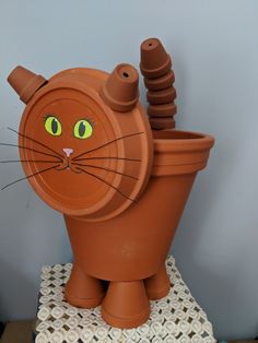 a clay pot with a cat's head sticking out of it