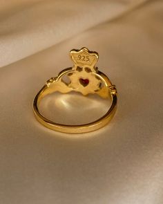 The Gold Claddagh Ring was a design from love. Especially for the Paris lovers! We have designed a cute ring inscription inside that says I ❤️ Paris. This Beautiful ring is 18kt gold plated silver with red cubic zirconia and faux pearls. Symbolic Heart-shaped Rings For Valentine's Day, Vintage Promise Jewelry For Valentine's Day, Heirloom Style Valentine's Day Jewelry Ring, Valentine's Day Heirloom Ring Jewelry, Valentine's Day Heirloom Ring, Symbolic Heart Shaped Rings As Gifts, Symbolic Jewelry For Promise On Valentine's Day, Symbolic Promise Jewelry For Valentine's Day, Symbolic Heart Shaped Wedding Rings