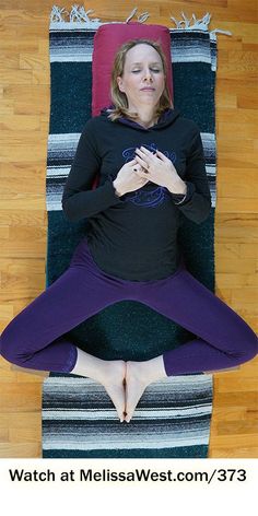 a woman is sitting in a yoga position