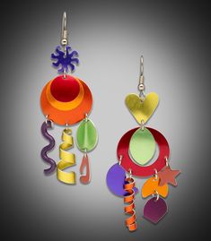 two colorful earrings are hanging from hooks