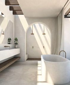 a large white bath tub sitting next to a bathroom sink in a room filled with windows