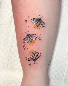 a woman's leg with three bees on it and stars in the sky above