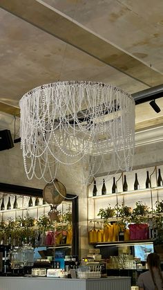 a chandelier hanging from the ceiling above a counter in a restaurant or bar