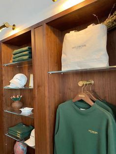 there are many items on the shelves in this closet, including t - shirts and hats