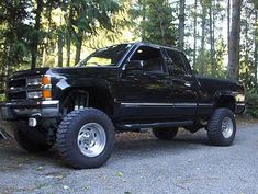 a black truck is parked in the woods