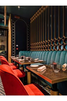 a restaurant with blue booths and red chairs, gold accents on the walls and floor