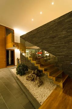 an indoor area with stairs, rocks and gravel on the ground in front of it