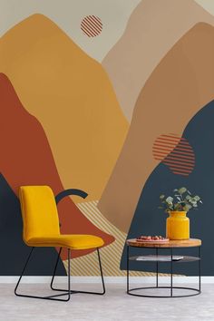 two yellow chairs sitting next to each other in front of a wall with an abstract painting on it