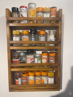 a wooden shelf filled with lots of different types of spices