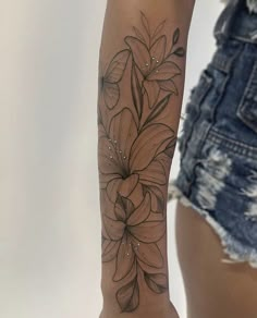 a woman's arm with a flower tattoo on the left side of her arm