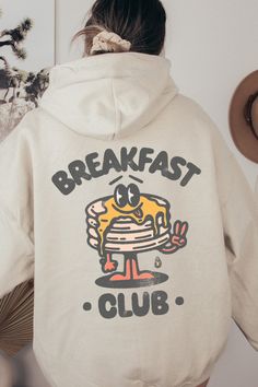 Get ready to be OBSESSED with your new favorite Breakfast Club Retro Pancake Hoodie. It's the cutest and most trendy way to emit all those vintage brunchy vibes! It is the perfect graphic hoodie to throw on all day every day! Crafted from the softest fabric, this Gildan 18500 hooded sweatshirt ensures the utmost comfort throughout the day. Oversized Cartoon Print Hoodie Sweatshirt, Oversized Crew Neck Hoodie With Cartoon Print, Oversized Cartoon Print Crew Neck Hoodie, Oversized Hooded Sweatshirt With Cartoon Print, Cozy Hoodie With Graphic Print For Loungewear, Cotton Hoodie With Cartoon Print For Loungewear, Cozy Graphic Print Hoodie For Loungewear, Cozy Hooded Sweatshirt With Graphic Print, Cozy Graphic Print Hoodie For Streetwear