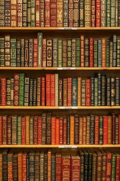 a book shelf filled with lots of books on top of wooden shelves next to each other