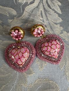 These adorable hearts are made with pink and gold swirls surrounded with tiny cut crystals and rhinestone chain and tiny seed beads they make the cutest accessories to any outfit approx 2.5 inches long and 1.5 inches wide I only use hypoallergenic stud earrings Pink Beaded Heart Pendant Jewelry, Pink Heart Beads Jewelry For Party, Cute Pink Heart Earrings With Heart Beads, Cute Pink Heart Earrings With Beads, Pink Heart-shaped Rhinestone Jewelry, Pink Double Heart Earrings For Party, Pink Beaded Heart Earrings For Party, Pink Beaded Heart Earrings For Valentine's Day, Handmade Pink Double Heart Jewelry