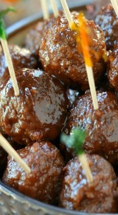 several skewered meatballs in a bowl with toothpicks sticking out of them