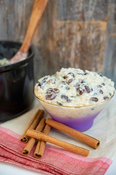 a bowl filled with oatmeal next to cinnamon sticks