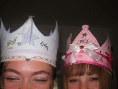 two girls wearing princess crowns and smiling at the camera with their faces close to one another