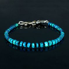 "Genuine Natural Ethiopian Welo Fire Blue Opal Gemstone Uncut Bead Beautiful Bracelet. Material: Ethiopian Opal & Black faceted Spinal bead Weight: 15.00 Cts. Colour : paraiba Blue Length : \"6\" Inches With Size Adjustable Chain upto \"8\" inches. Bead Shape : Rondelle Beads Size : 3.5 To 4.5 mm. Welo fire Opal Gemstone Jewelry/Bracelet." Fire Blue, Magical Jewelry, Bracelet Blue, Opal Bracelet, Bracelet Black, Jewelry Bracelet, Blue Opal, Opal Gemstone, Bead Bracelet