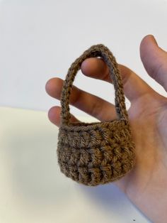 a hand holding a small crocheted purse