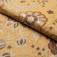 the fabric is yellow and brown with floral designs on it's sides, as well as