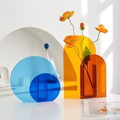 three vases with flowers in them sitting on a white table next to each other