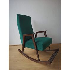 a green chair sitting on top of a hard wood floor