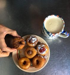 doughnuts on a plate next to a cup of coffee