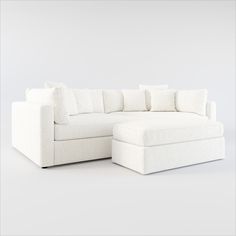 a white couch and ottoman with pillows on it