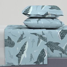 two sheets with dolphins on them are stacked next to each other