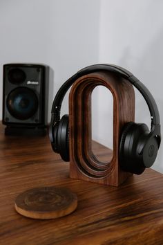 headphones on top of a wooden table next to a speaker and other items in the background