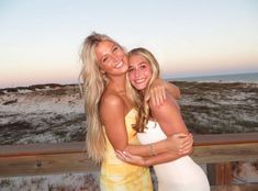 two beautiful young women hugging each other on the beach