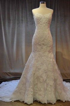 a wedding dress on display in front of a curtain