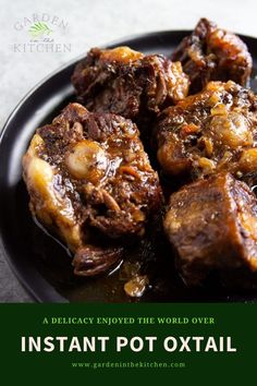 a black plate topped with meat covered in gravy