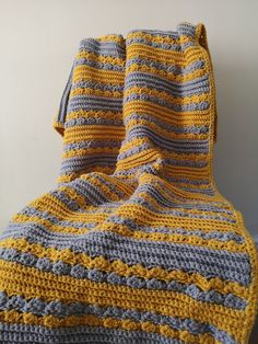 a crocheted blanket on top of a bed