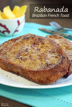 two pieces of french toast on a white plate next to a bowl of potato wedges