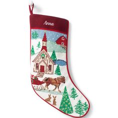 an embroidered christmas stocking with a horse and sleigh in front of a house