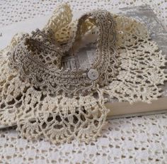 two crocheted doily on top of a book with a button in the middle