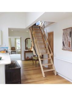 there is a staircase in the middle of this room with wood floors and white walls