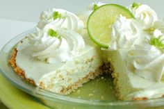 a close up of a slice of cake with whipped cream and limes on top