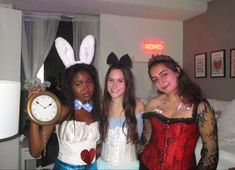 three girls dressed up in costumes posing for the camera with an alarm clock on their chest