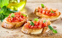 three pieces of bread topped with tomatoes and basil