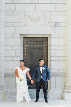 a bride and groom holding hands in front of a door at the entrance to an old building