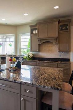 a large kitchen with granite counter tops and wooden cabinets, along with an island in the middle